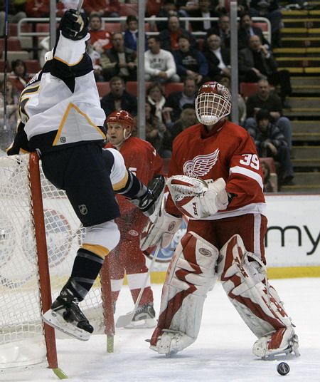 Brnakář Dominik Hašek z Detroitu sleduje, jak se nashvillský obránce Greg Zanon raduje z gólu v jeho brance. | Foto: Reuters