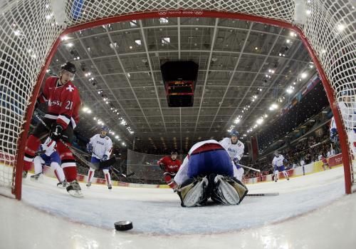 Švýcar Patrik Fischer (vlevo) skóruje do branky italského gólmana Jasona Muzzattiho. | Foto: Reuters