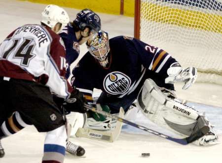 Ian Laperriere z Colorada (v bílém) se bráněný Radkem Dvořákem snaží překonat gólmana Ty Conklina z Edmontonu. | Foto: Reuters