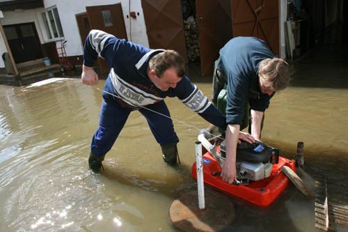 Zatopení domu zabránilo především intenzivní čerpání vody ze dvora. A hráze z hlíny a pytlů s pískem. | Foto: Ondřej Besperát, Aktuálně.cz