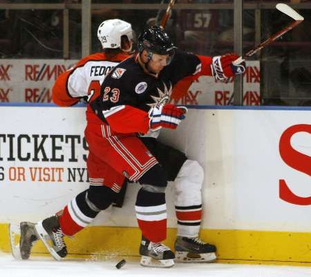 Obránce New Yorku Rangers Karel Rachůnek (v modrém) bojuje u hrazení Todda Fedoruka z Philadelphie. | Foto: Reuters