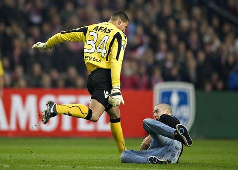 Brankář Alkmaaru Esteban Alvarado kope do fanouška Ajaxu Amsterodam | Foto: EPA