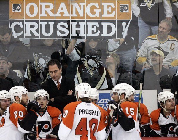 Střídačka Philadelhie po prohraném finále Východu. Vpředu uprostřed stojí Václav Prospal čelem k posměšnému plakátu pittsburghského fandy. Nápis "Orange crushed" lze přeložit jako "Oranžoví rozdrceni" i jako "Pomeranč vymačkán". Oranžová je klubová barva Philadelphie. | Foto: Reuters