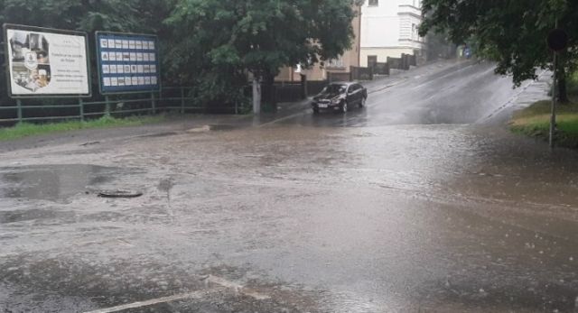 Ulici Fibichova policie a hasiči kvůli přeplněné kanalizaci a potoku raději uzavřeli. Po opadnutí vody se chystají na místo vrátit a odčerpat vodní lagunu. | Foto: ČTK