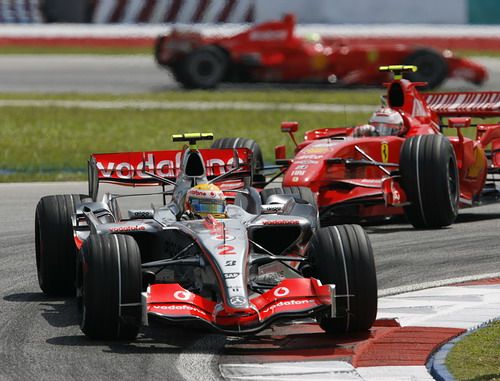 Lewis Hamilton s McLarenem jede před pilotem Ferrari Kimi Räikkönena. Z aním v dáli dadlší Ferrari Felipe Massy. | Foto: Reuters