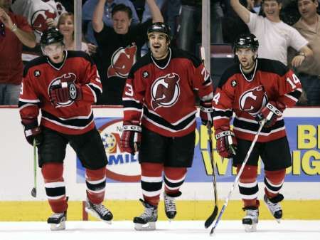 Hokejisté New Jersey (zleva Zach Parise, Scott Gomez a Brian Gionta) se radují z branky v síti Caroliny. | Foto: Reuters