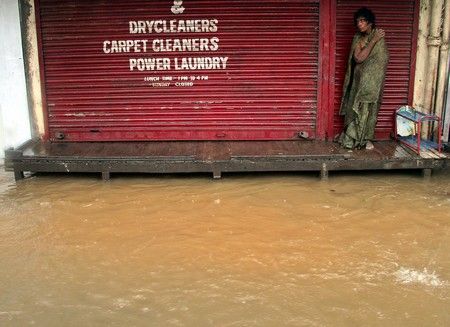 Muž stojí před uzavřeným obchodem v Bombaji. | Foto: Reuters