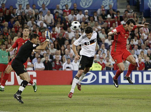 Sporný moment. Ballack přistrčil Paula Ferreiru (vpravo) a hlavou střílí gól brankáři Ricardovi. | Foto: Reuters