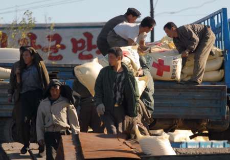 Severokorejci vykládají na břehu řeky Yalu humanitární pomoc. Mnoho obyvatel země trpí hladem. | Foto: Reuters