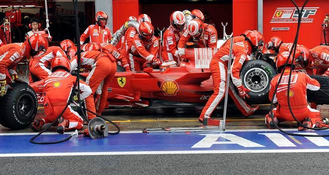 Mechanici Ferrari při zastávce Kimiho Räikkönena v boxech | Foto: Reuters