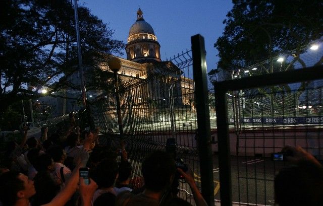 Fanoušci se snaží vyfotit monopost formule jedna v jedné ze zatáček na okruhu Marina Bay v Singapuru. | Foto: Reuters