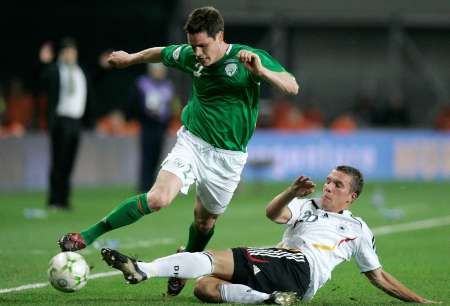 Irský reprezentant Steve Finnan v souboji s Němcem Lukasem Podolskim v kvalifikačním utkání skupiny D v Dublinu. | Foto: Reuters