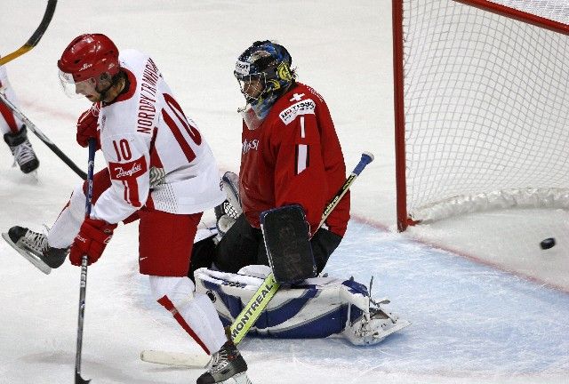 Švýcarský gólman Jonas Hiller pouští střelu Dána Jespera Damgaarda, před ním cloní Bo Nordby Tranholm. | Foto: Reuters