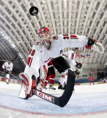 Kanadský gólman Martin Brodeur se marně natahuje po puku v zápase olympijského turnaje se Švýcarskem. Kanaďané překvapivě prohráli 0:2. | Foto: Reuters/Elsa