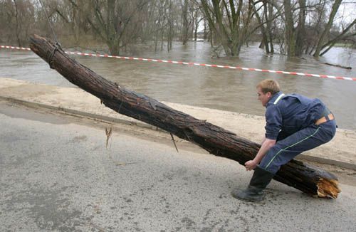 Vzedmuté řeky a potoky mnohde ohrožují mosty naplaveninami. S takovými si museli poradit hasiči v Micmanicích na Znojemsku. Vyprošťování této klády se stalo malou událostí. Operaci, která se nakonec hasičům zdařila, přihlížela velká skupina místních obyvatel trpělivě několik desítek minut. | Foto: Ondřej Besperát, Aktuálně.cz