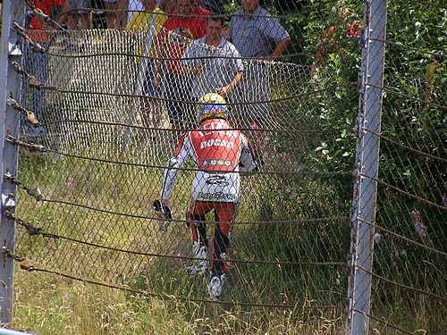 Australan Troy Bayliss zvolil po pádu v závodě superbiku v Brně nejkratší cestu do depa, přelezl přes plot. | Foto: Radek Vičík