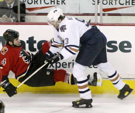 Útočník Edmontonu Oilers Petr Nedvěd (vpravo) poslal k zemi Romana Hamrlíka z Calgary Flames v zápase zámořské NHL. | Foto: Reuters