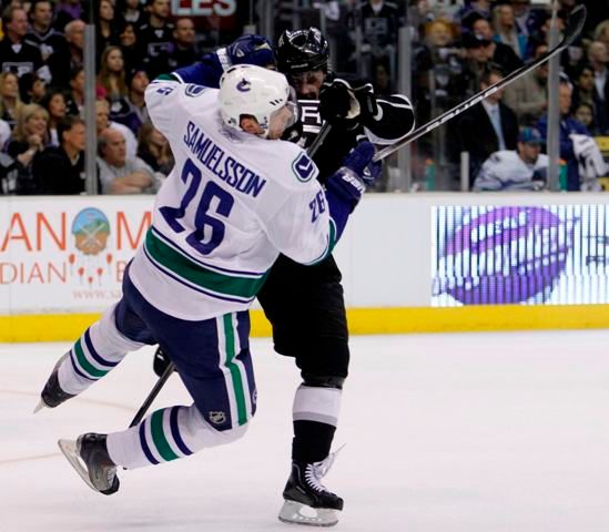 Dustin Brown dostává klasického "stroma". | Foto: Reuters