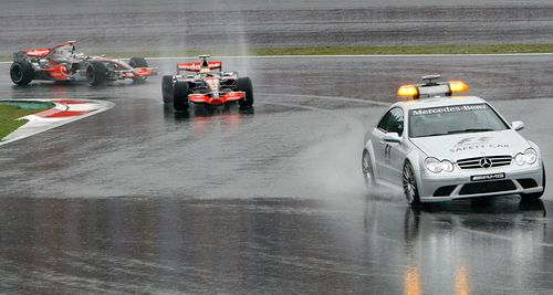 Lewis Hamilton (uprostřed) a Fernando Alonso z McLarenu jedou za zaváděcím vozidlem v úvodu Velké ceny Japonska. | Foto: Reuters