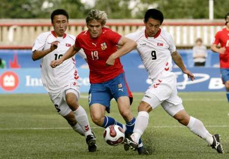 Severokorejec Kim Kyong-il (vlevo) a Pak Song-chol (vpravo) brání Luboše kaloudu v utkání MS do 20 let v Kanadě. | Foto: Reuters