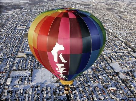 Takahide Nakatsugawa letí v balonu nad městem Obihiro na severojaponském ostrově Hokkaidó. Znak na balónu znamená "Daiheigen" - neboli "širá rovina". Přesně tak totiž zní jméno Nakatsugawaho hotelu. | Foto: Reuters