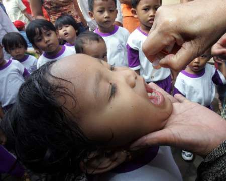 Jakarta (Indonésie) - Indoneský zdravotník očkuje dítě během masového očkování proti dětské obrně, která se konala ve středu v Indonesii. | Foto: Reuters