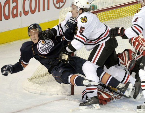 Aleš Hemský padá po zásahu chicagského obránce Brenta Sopela. | Foto: Reuters