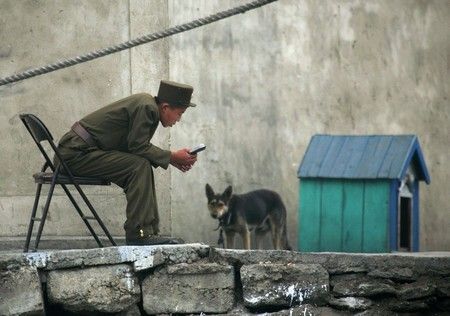 Severokorejský voják si čte ve městě Sinujiu na severokorejské straně řeky Ja-lu, která odděluje Severní Koreu od Číny | Foto: REUTERS / Reinhard Krause