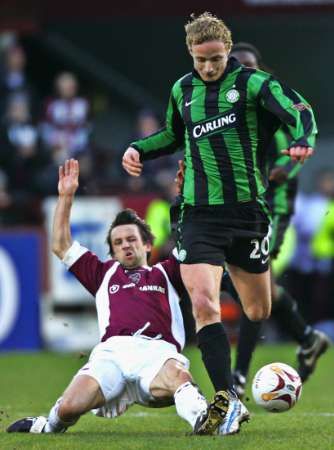 Český fotbalista Jiří Jarošík (vpravo) ze Celtiku Glasgow uniká Neilu McCannovi z Heart of Midlothian v zápase skotské ligy. | Foto: Reuters