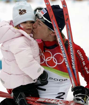 Gratulantka Lucie se zlatou mámou Kateřinou Neumannovou v cíli běhu na 30 km na ZOH v Turíně. | Foto: Dominic Ebenbichler