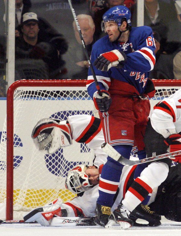 Gólman New Jersey Martin Brodeur padá s odhaleným hledím po střetu s nohou Jaromíra Jágra. | Foto: Reuters