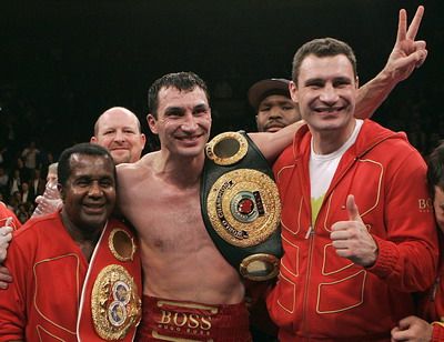 Ukrajinský boxer Vladimir Kličko (uprostřed) slaví triumf nad Američanem Calvinem Brockem. Vpravo je jeho bratr Vitalij a vlevo kouč Emanuel Steward. | Foto: Reuters