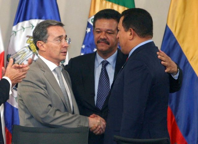 Kolumbijský prezident Álvaro Uribe (vlevo) si podává ruku s venezuelským Hugo Chávezem (vpravo). Uprostřed dominikánský Leonel Fernandéz. | Foto: Aktuálně.cz