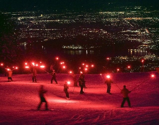 Z Grouse Mountain nad kanadským Vancouverem se spouští lyžaři vyzbrojení slavnostními ohni, které oznamují rok do zahájení olympijských her. | Foto: Reuters