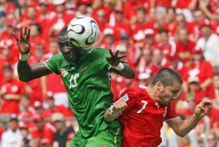 Cherif Toure Mamam z Toga (vlevo) v hlavičkovém souboji se Švýcarem Ricardo Cabanasem. | Foto: Reuters