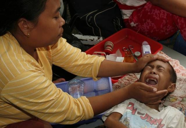 Matka drží svého syna v provizorní nemocnici v Bengkulu. Chlapec utrpěl zranění při zemětřesení. | Foto: Reuters