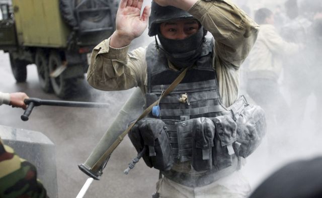 Středa v Biškeku: Demonstranti se pokoušejí vzít policistovi raketomet | Foto: Reuters