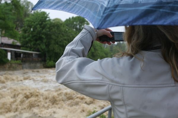 "Jestli bude takto valit, tak se to v noci vylije," obávají se dalšího deště lidé na mostě. "Už to o metr spadlo. Hlásí sice průtrže, teď to ale podle mně schytají hlavně ti níž po proudu," oponuje o kus dál starší pán v ulici obložené pytli. | Foto: Karel Toman