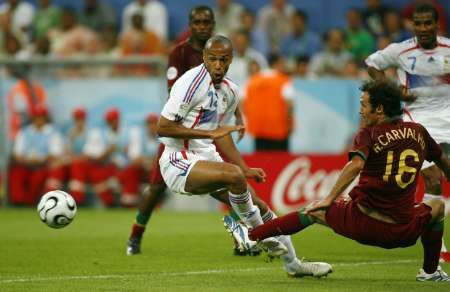 Portugalec Ricardo Carvalho (v červeném) fauluje v pokutovém území Thierry Henryho z Francie. | Foto: Reuters