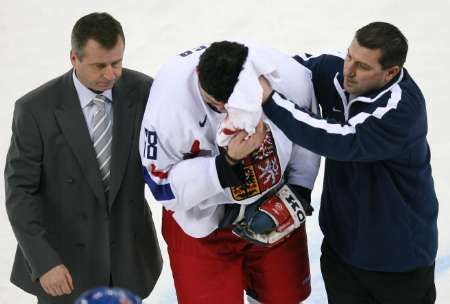 Zraněný Jaromír Jágr míří s pomocí lékaře a maséra pryč z ledu. | Foto: Reuters