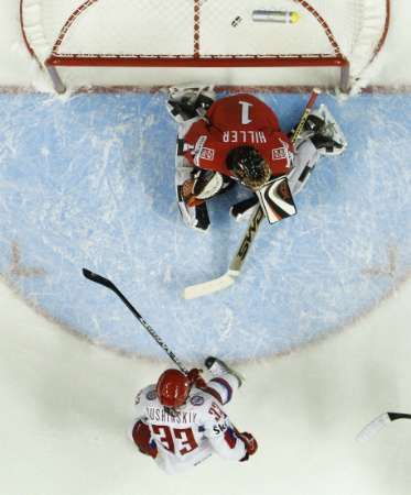 Rus Maxim Sušinskyj překonává švýcarského brankáře Jonase Hillera. | Foto: Reuters