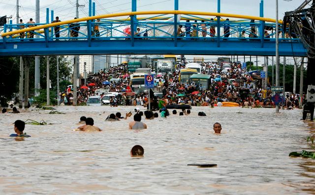 Obyvatelé Cainta plavou k vyvýšenému místu. | Foto: Reuters