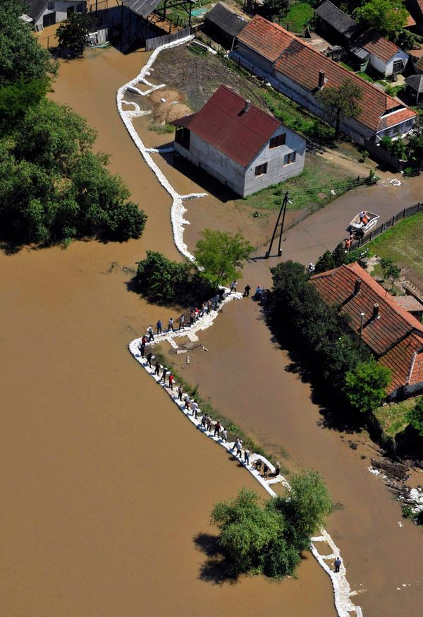 Mravenčí práce. Hasiči i lidé z obce Onod v Maďarsku se snaží uchránit obydlí před rozvodněnou řekou Sajo. | Foto: Reuters