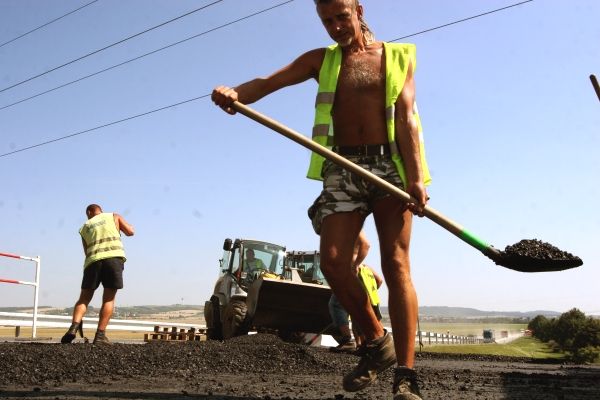 Dálniční epopej - Fotografie z jedné z mnoha výspravek děrovaté D1. "Doděláme tenhle sjížďák a pak jedem asfaltovat silnici mezi Vlkošem a Troubkami," jmenuje řidič firmy M-Silnice. "Je to takový všelijaký, nikdo nic neví." | Foto: Karel Toman