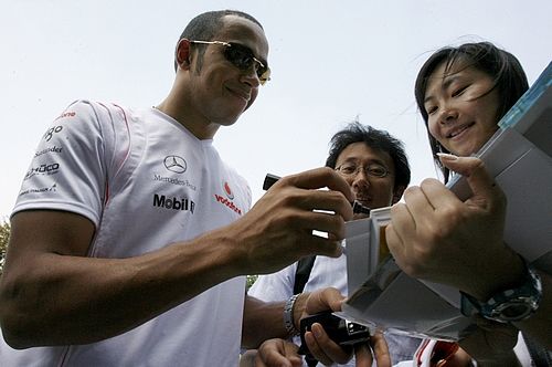 Usměvavý Lewis Hamilton rozdává autogramy svým čínským fanouškům před závodem v Šanghaji. | Foto: Reuters