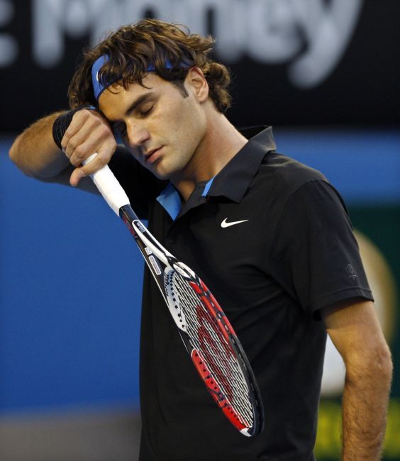 Roger Federer si otírá pot z čela. Melbourne, Austrálie | Foto: Reuters