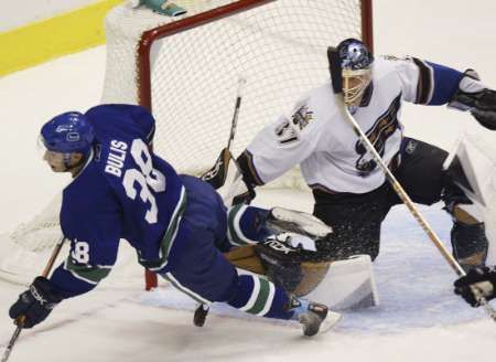 Útočník Vancouveru Jan Bulis (vlevo) padá atakován gólmanem Olafem Kölzig z Washingtonu. Vancouver zápas vyhrál 3:2. | Foto: Reuters