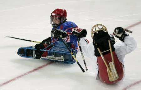 Paralympijská soutěž ve sledge hokeji je v plném proudu. Na snímku jsou v souboji Brit Nathan Stephens (vlevo) a Kanaďan Greg Westlake. | Foto: Aktuálně.cz