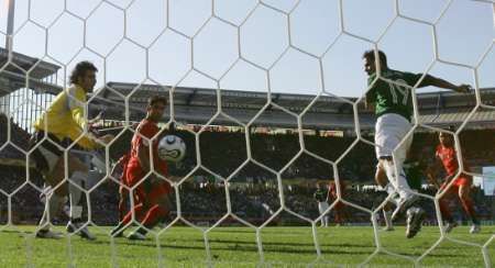 Mexičan Omar Bravo (v zeleném) právě dává gól do branky Ebrahima Mirzapoura z Íránu. | Foto: Reuters