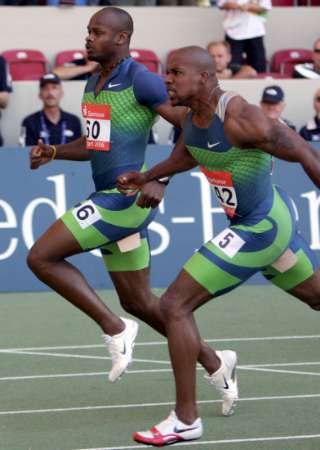 Jamajský sprinter Asafa Powell (vlevo) a Američan Leonard Scott protínají cílovou pásku běhu na 100 m na Světovém atletickém finále ve Stuttgartu. | Foto: Reuters